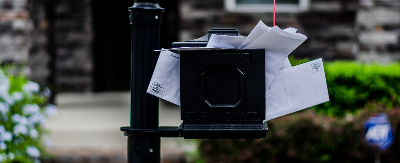Black mailbox stuffed full of mail