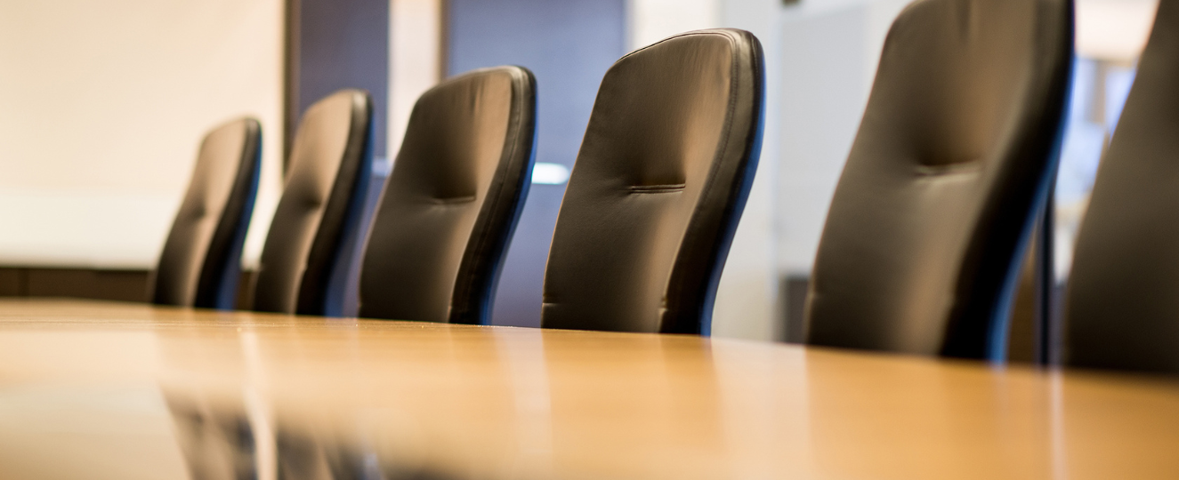 Row off empty chairs in a conference room.